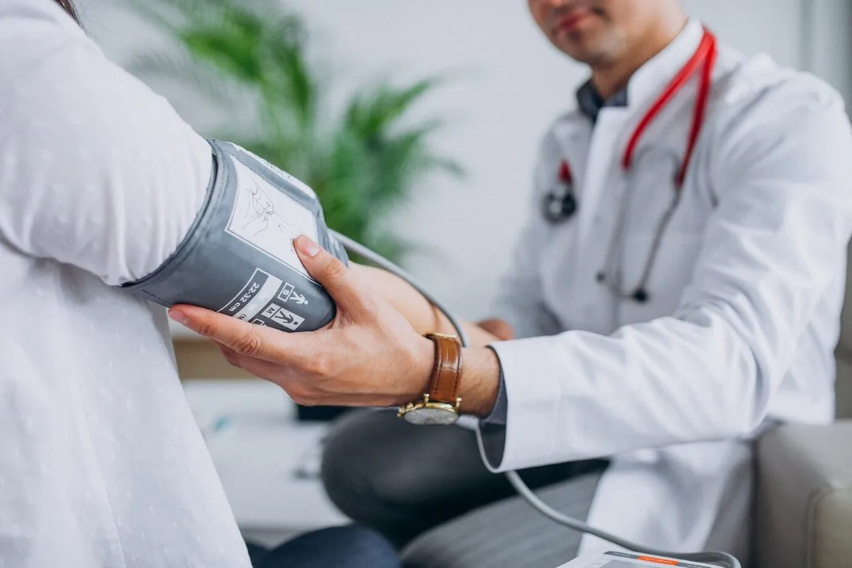A doctor measuring a patient’s blood pressure with a cuff