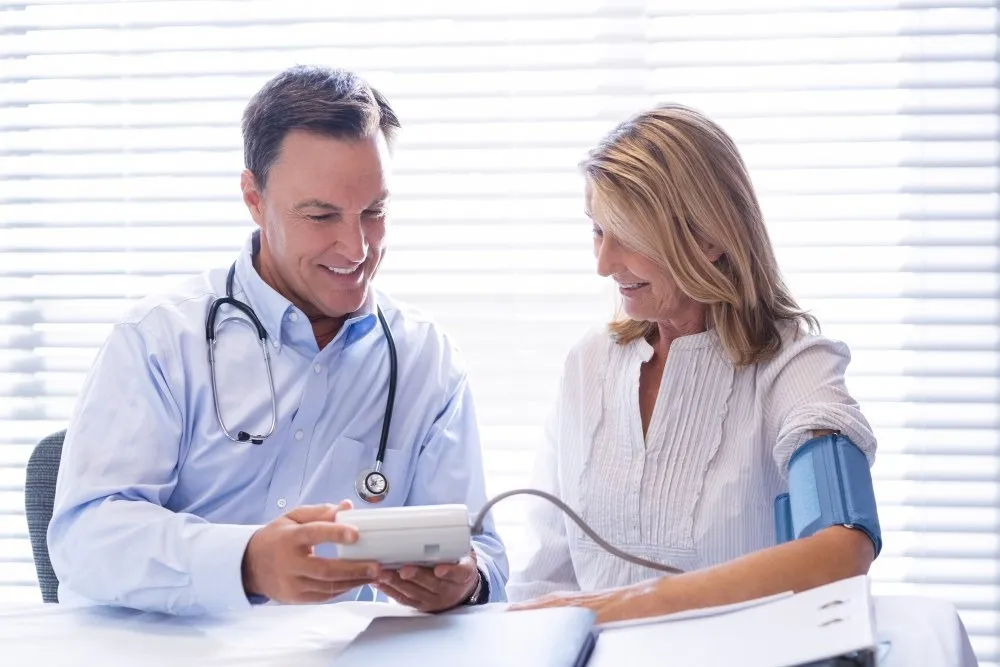 A doctor reviewing results on a tablet with a patient